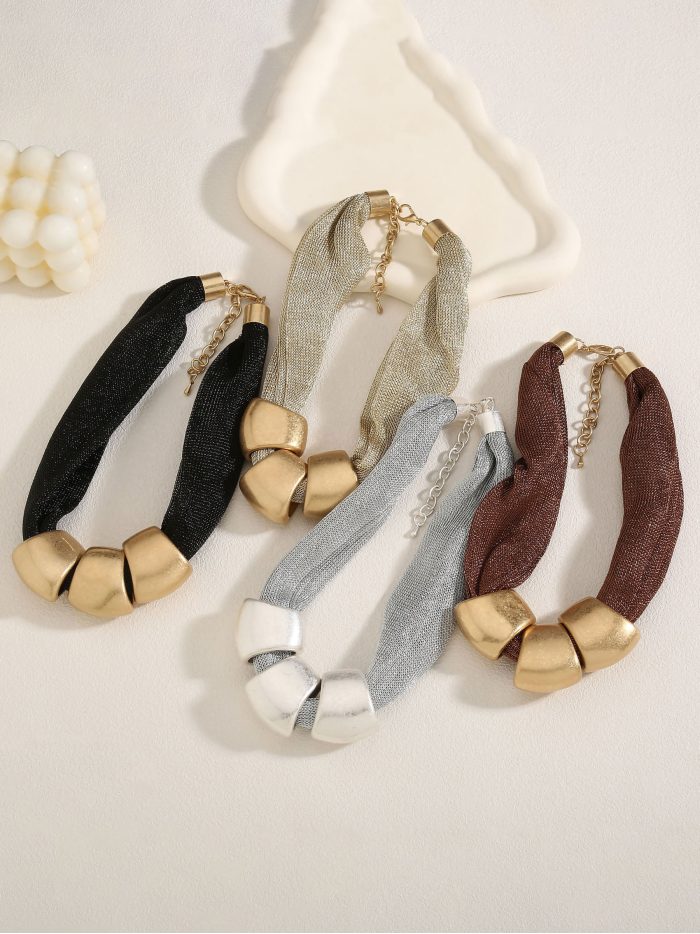 Collana choker a maglia con anelli dorati.