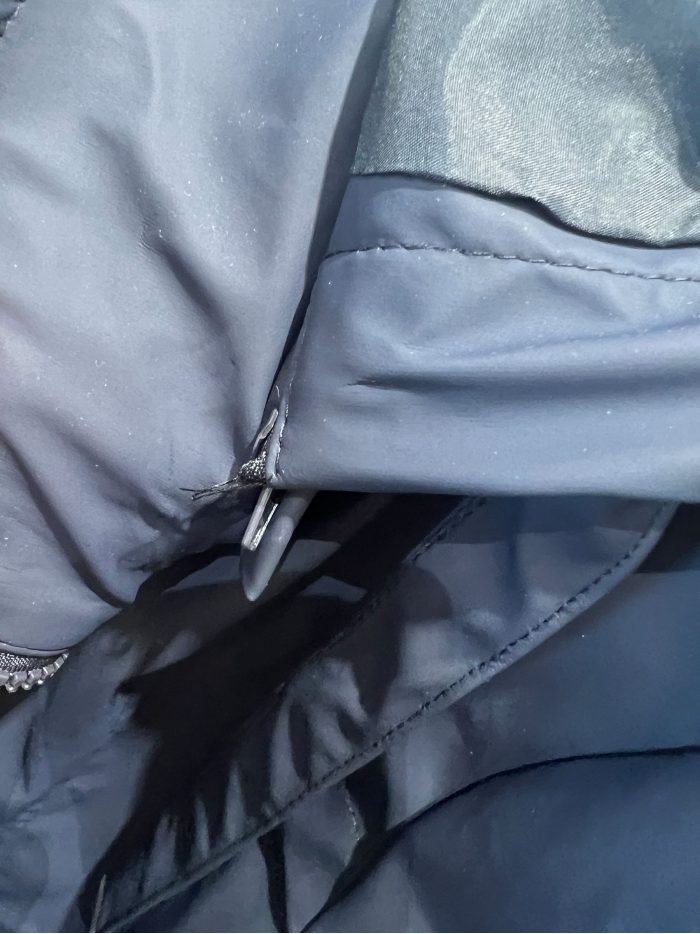 Parka emborrachada com capuz e botões de pressão.