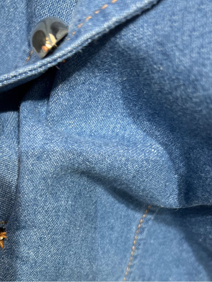 Gilet en denim avec fermetures décoratives.