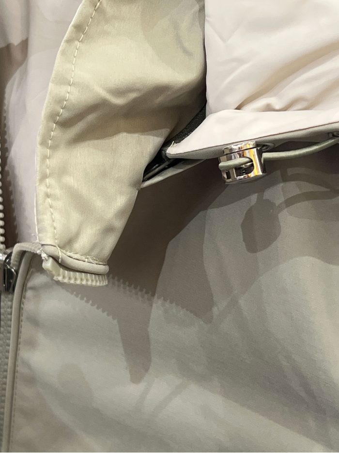 Giacca reversibile con cappuccio e vita regolabile.