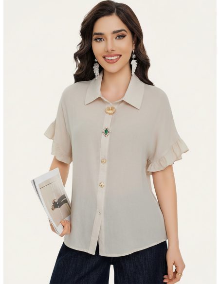 Camisa com mangas bufantes e botões cravejados de joias.