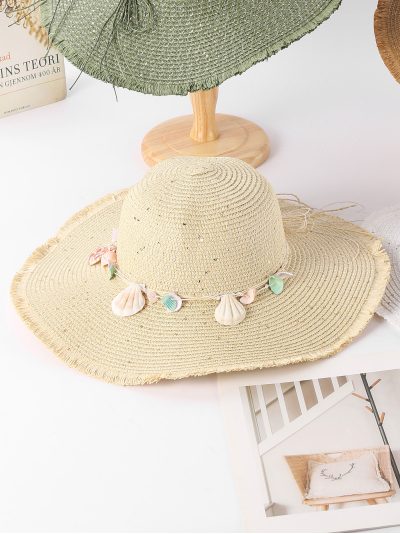 Sombrero de rafia con borde desflecado y colgantes de conchas