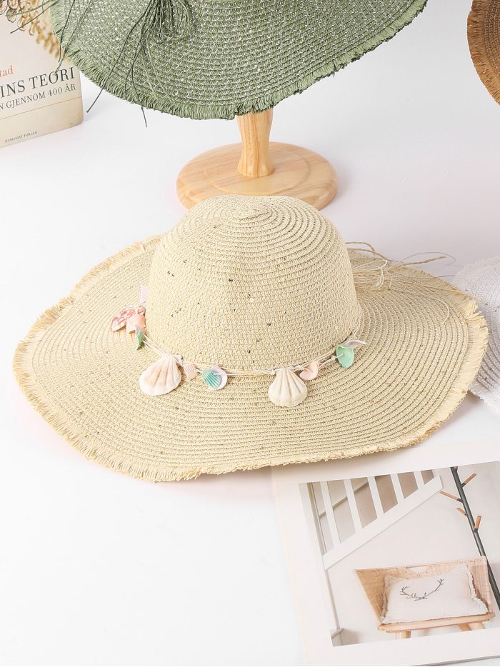 Sombrero de rafia con borde desflecado y colgantes de conchas