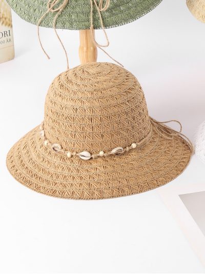 Sombrero de rafia con textura geométrica y banda de conchas