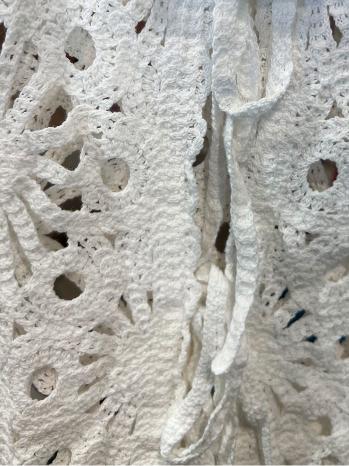 Gilet au crochet orné d'un nœud et de fleurs ajourées