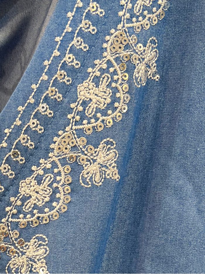 Blusa símil denim con volantes y bordado en escote