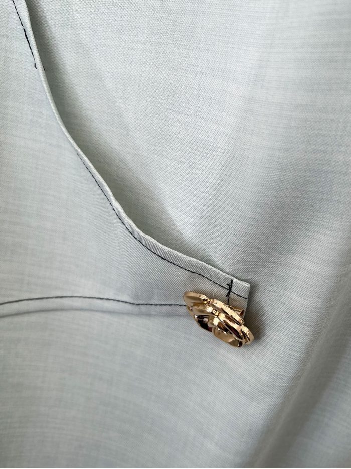 Completo composto da camicetta senza maniche con bottone a fiore e pantaloncini