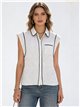 Blusa sem mangas com estampa de bolinhas e detalhes contrastantes.
