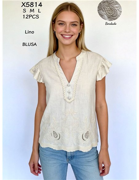 Camicetta in lino con volant e ricami traforati.