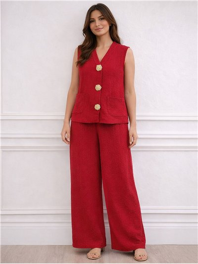Conjunto de colete e calça texturizados com botões dourados.
