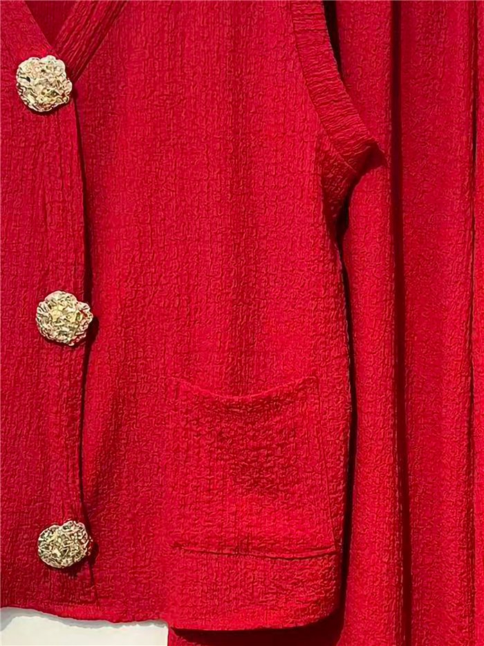 Conjunto de colete e calça texturizados com botões dourados.