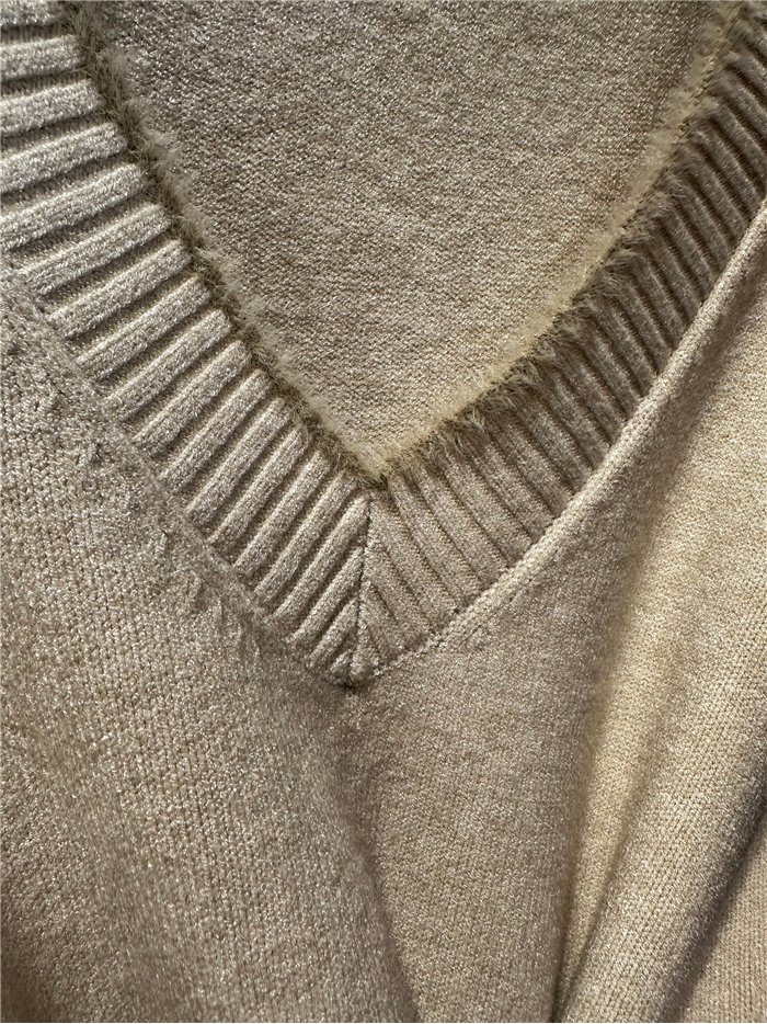 Suéter com decote em V e detalhes contrastantes.