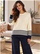Completo composto da maglione e pantaloni oversize a righe.