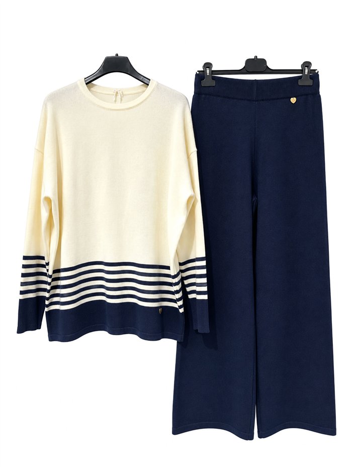 Completo composto da maglione e pantaloni oversize a righe.