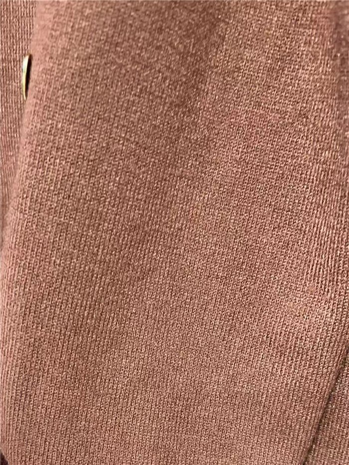 Completo composto da maglione e pantaloni con bottoni laterali